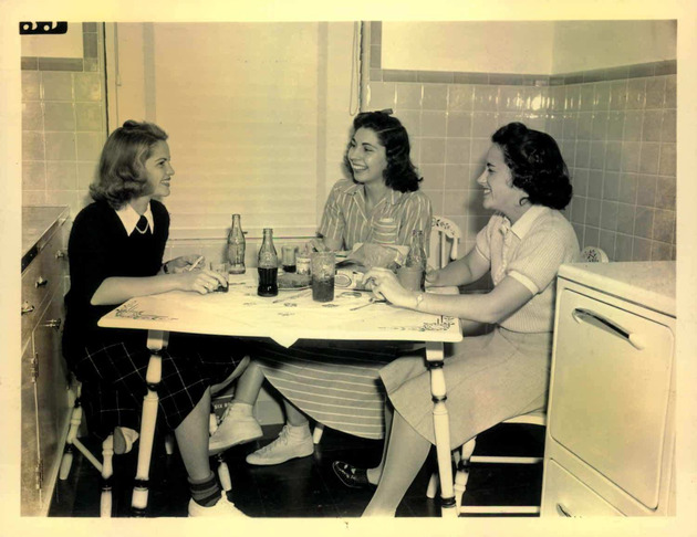 Students socialize in a small dormitory kitchen